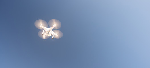 Image showing White UAV Quadcopter Drone in Flight Blue Sky