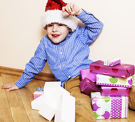 Image showing little cute boy with Christmas gifts at home. close up emotional