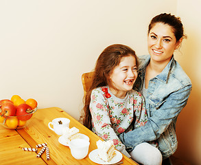 Image showing young mother with daughter on kitchen drinking tea together hugg