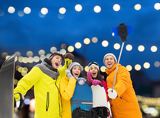 Image showing happy friends with snowboards and smartphone