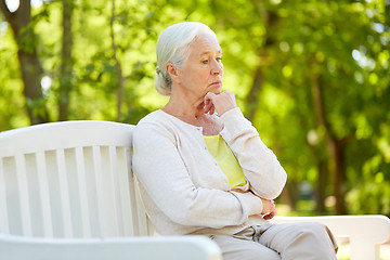 Image showing sad senior woman sitting on bench at summer park