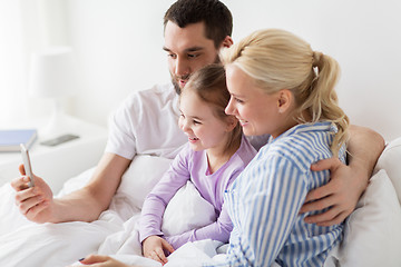 Image showing happy family taking selfie by smartphone at home