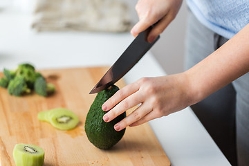 Image showing woman hands chopping avocado on cutting board