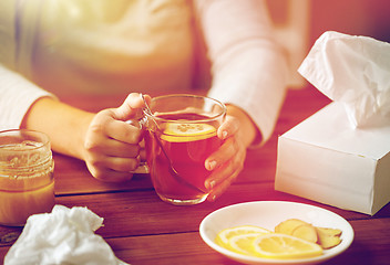 Image showing close up of ill woman drinking tea with lemon