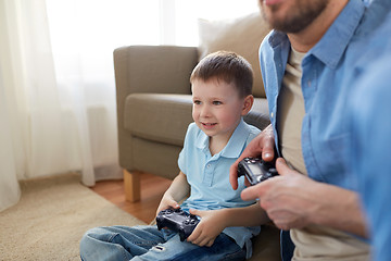 Image showing father and son playing video game at home