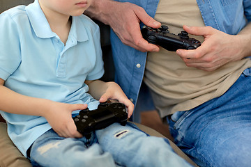 Image showing close up of father and son playing video game