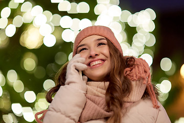 Image showing happy woman calling on smartphone at christmas