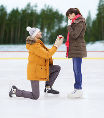 Image showing happy couple with engagement ring on skating rink