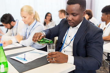 Image showing businessman drinking water at business conference