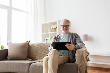 Image showing senior man with tablet pc sitting on sofa at home