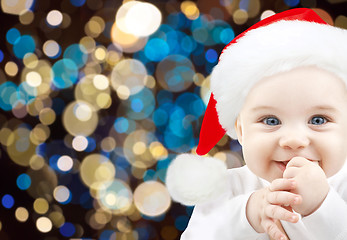 Image showing happy baby in santa hat over christmas lights