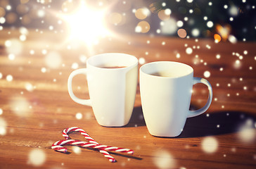 Image showing christmas candy canes and cups on wooden table