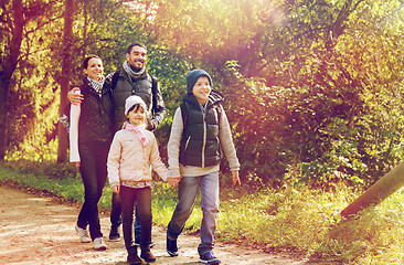 Image showing happy family with backpacks hiking in woods