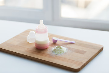 Image showing infant formula, baby bottle and scoop on board