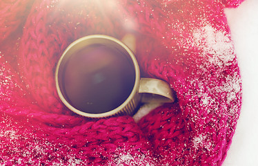 Image showing close up of tea or coffee and winter scarf in snow