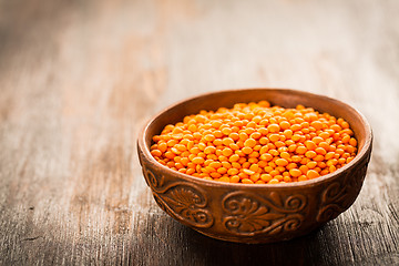 Image showing Red lentils in a bowl on old wooden table