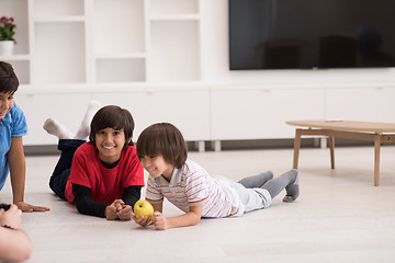 Image showing boys having fun with an apple on the floor