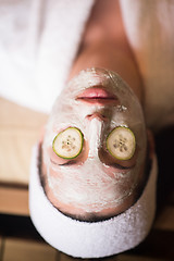 Image showing woman is getting facial clay mask at spa