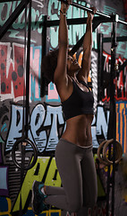 Image showing black woman doing pull ups