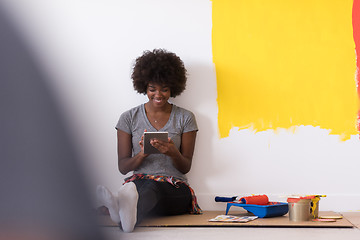 Image showing back female painter sitting on floor