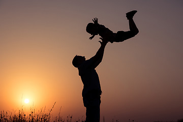 Image showing Father and son playing in the park at the sunset time.