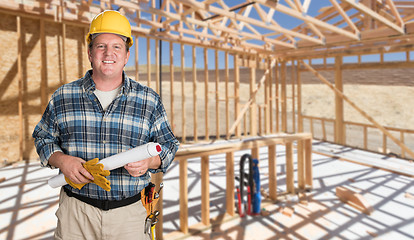 Image showing Male Contractor With House Plans Wearing Hard Hat Inside New Hou