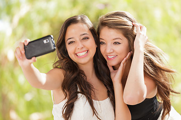 Image showing Two Attractive Mixed Race Girlfriends Using Their Smart Cell Pho