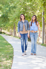 Image showing Two Beautiful Ethnic Twin Sisters Walking Outdoors.