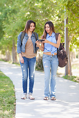 Image showing Two Beautiful Young Ethnic Twin Sisters With Backpacks Using A S