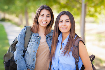 Image showing Two Beautiful Young Ethnic Twin Sisters With Backpacks Walking O