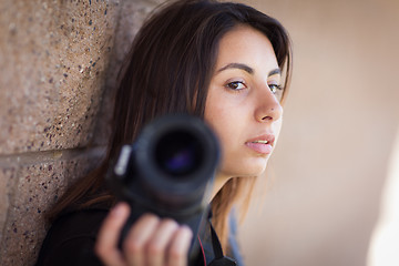 Image showing Young Adult Ethnic Female Photographer Against Wall Holding Came