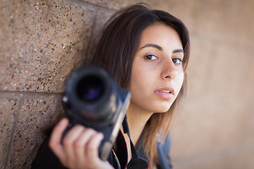 Image showing Young Adult Ethnic Female Photographer Against Wall Holding Came