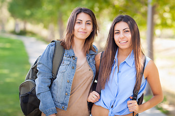Image showing Two Beautiful Young Ethnic Twin Sisters With Backpacks Walking O