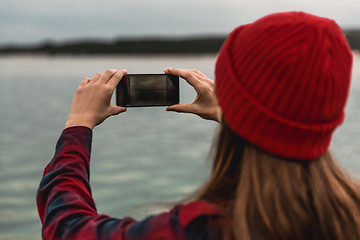 Image showing Woman taking pictures with a cellphone