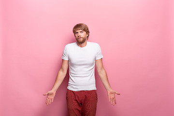 Image showing Serious businessman having no idea raised his hands