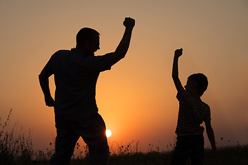 Image showing Father and son playing in the park at the sunset time.