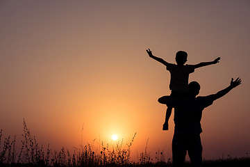 Image showing Father and son playing in the park at the sunset time.