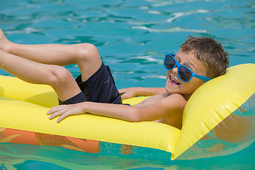 Image showing happy child playing on the swimming pool at the day time.