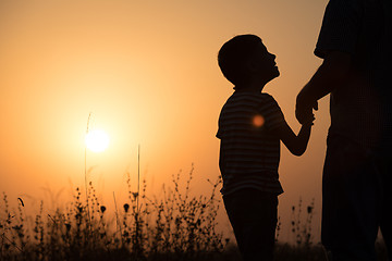 Image showing Father and son playing in the park at the sunset time.