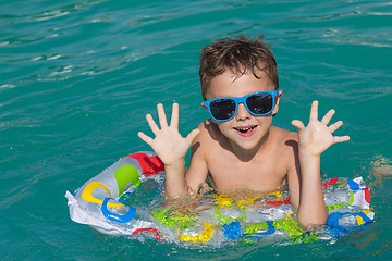 Image showing happy child playing on the swimming pool at the day time.