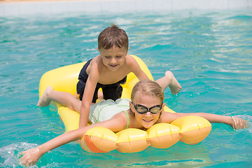 Image showing Two happy children playing on the swimming pool at the day time.