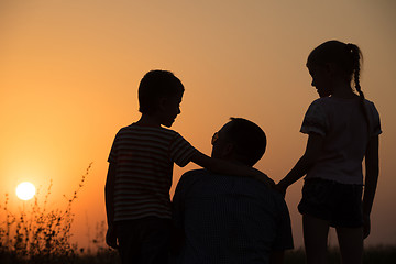 Image showing Father and children playing in the park at the sunset time.