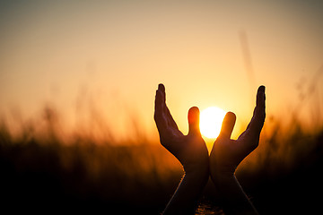 Image showing silhouette of female hands during sunset. 