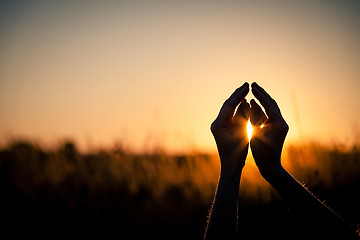 Image showing silhouette of female hands during sunset.