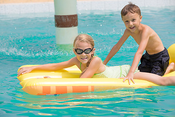 Image showing Two happy children playing on the swimming pool at the day time.