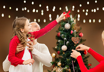 Image showing happy family decorating christmas tree at home