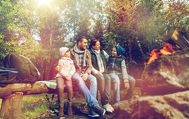 Image showing happy family sitting on bench at camp fire