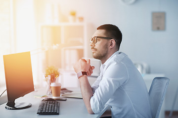 Image showing businessman in glasses sitting at office computer