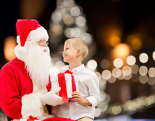 Image showing santa claus and happy boy with christmas gift