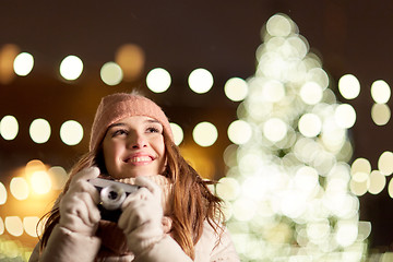 Image showing happy young woman with camera over christmas tree